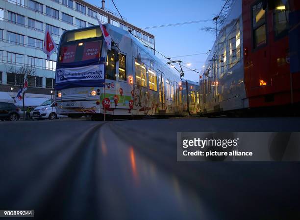 March 2018, Germany, Cologne: Trams with verdi flags parked outside the Koelner Verkehrsbetriebe depot. The Verdi union has called warning strikes in...