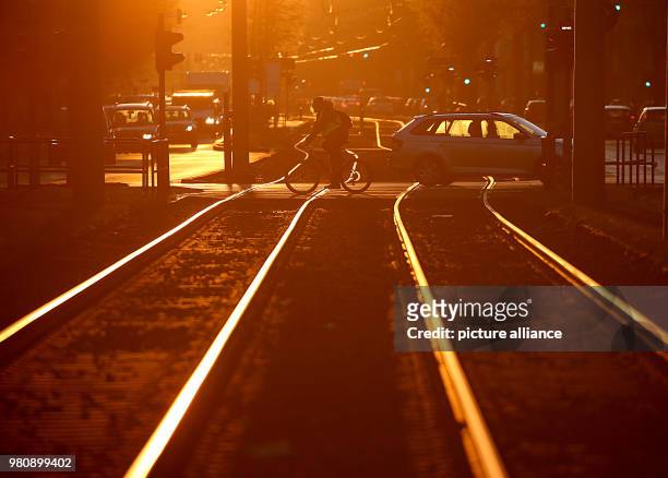 March 2018, Germany, Cologne: A cyclist crosses tram tracks during the morning rush hour. The Verdi union has called warning strikes in the public...