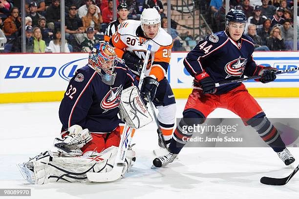 Grant Clitsome of the Columbus Blue Jackets attempts to block out Sean Bergenheim of the New York Islanders as goaltender Mathieu Garon of the...