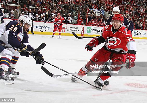 Patrick Dwyer of the Carolina Hurricanes battles for control of the puck with Johnny Oduya of the Atlanta Thrashers during their NHL game on March...