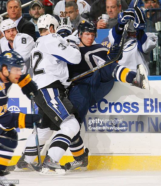 Matt Smaby of the Tampa Bay Lightning checks Toni Lydman of the Buffalo Sabres into the boards during the first period of the Sabres game against the...