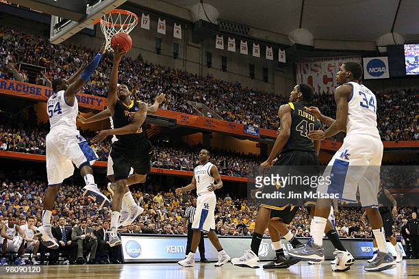 Devin Ebanks of the West Virginia Mountaineers drives to the basket against Patrick Patterson of the Kentucky Wildcats during the east regional final...
