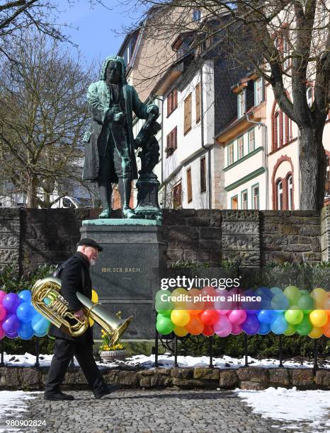 March 2018, Germany, Eisenach: A musician from the Posaunenchor Eisenach trombone band passes the Bach memorial outside the Bachhaus as he arrives...