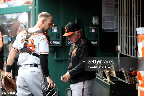 Catcher Caleb Joseph of the Baltimore Orioles talks with manager Buck Showalter before the start of the first inning against the Washington Nationals...