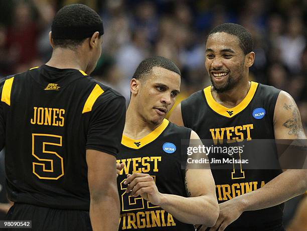 Kevin Jones, Joe Mazzulla and Da'Sean Butler of the West Virginia Mountaineers react in the second half against the Kentucky Wildcats during the east...