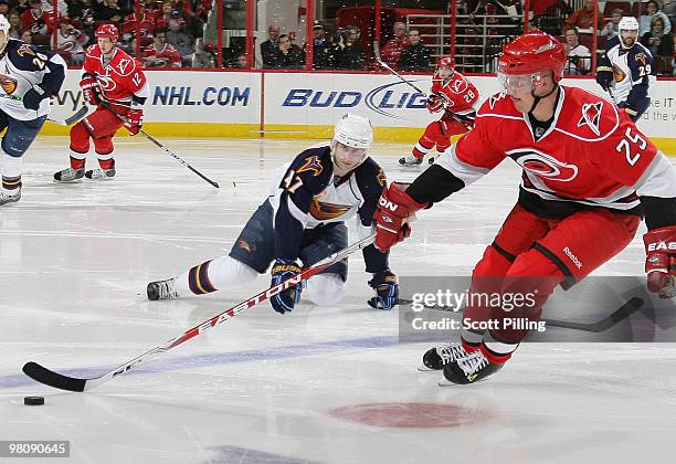 Rich Peverley of the Atlanta Thrashers falls to the ice while battling against Joni Pitkanen of the Carolina Hurricanes during their NHL game on...