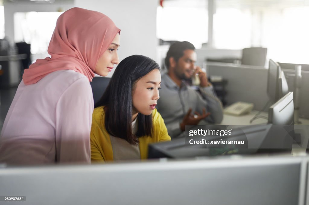 Weiblichen Kolleginnen und Kollegen arbeiten am Computer-Schreibtisch