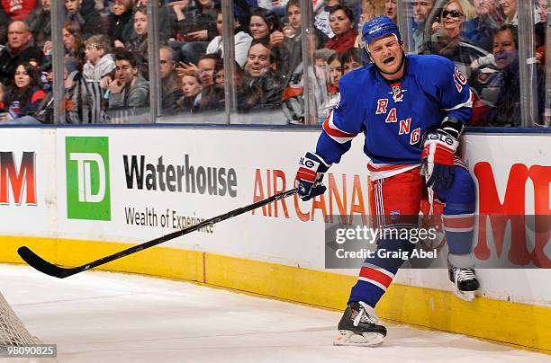 Sean Avery of the New York Rangers winces in pain and holds his knee after being checked into the end boards during game action. Avery left the game...