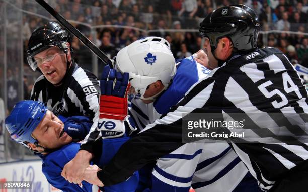 Sean Avery of the New York Rangers battles with Dion Phaneuf of the Toronto Maple Leafs as linesman David Brisebois and Greg Devorski try to break...