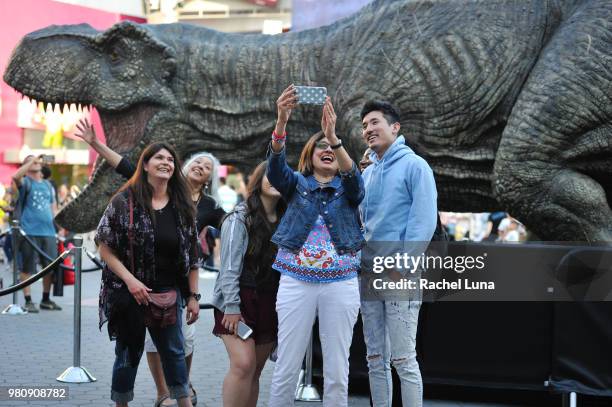 Fans take a selfie with a Tyrannosaurus rex replica before an advanced screening of "Jurassic World: Fallen Kingdom" at Universal CityWalk on June...