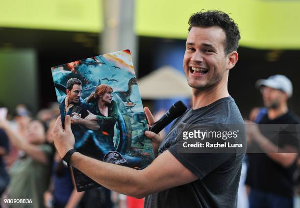Universal CityWalk Emcee Fernando Duran gives out Jurassic Park posters to fans before an advanced screening of "Jurassic World: Fallen Kingdom" at...