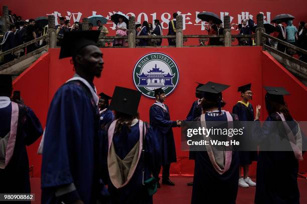 The international graduates poses take pictures after their ceremony of Wuhan University on June 22, 2018 in Wuhan, China.China is forecast to...