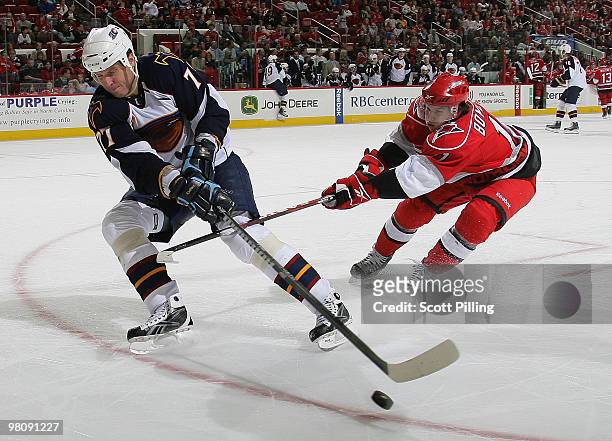 Zach Boychuk of the Carolina Hurricanes attempts to knock Pavel Kubina of the Atlanta Thrashers off the puck during their NHL game on March 27, 2010...