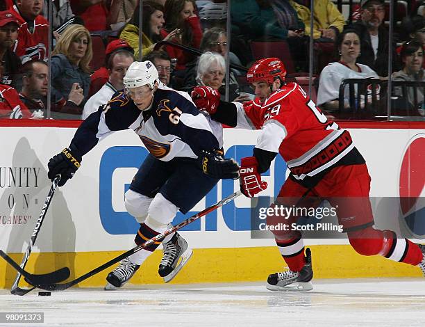 Chad LaRose of the Carolina Hurricanes battles for the puck along the boards with Maxim Afinogenov of the Atlanta Thrashers during their NHL game on...