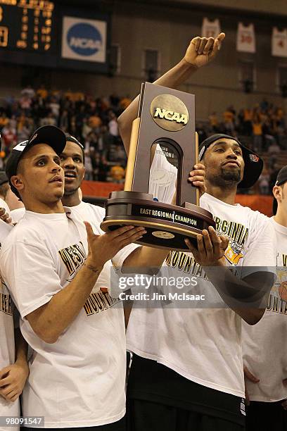 Joe Mazzulla and Da'Sean Butler of the West Virginia Mountaineers celebrate with the East Regional trophy after West Virginia won 73-66 against the...