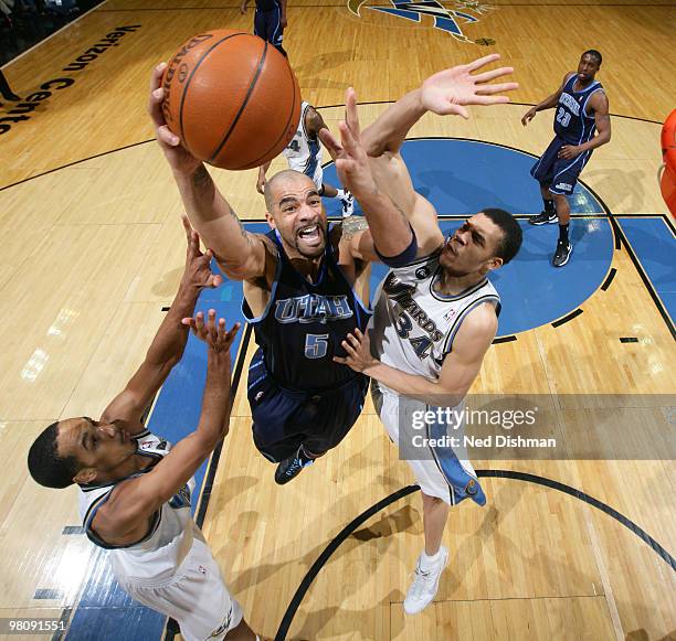 Carlos Boozer of the Utah Jazz shoots against JaVale McGee and Shaun Livingston of the Washington Wizards at the Verizon Center on March 27, 2010 in...