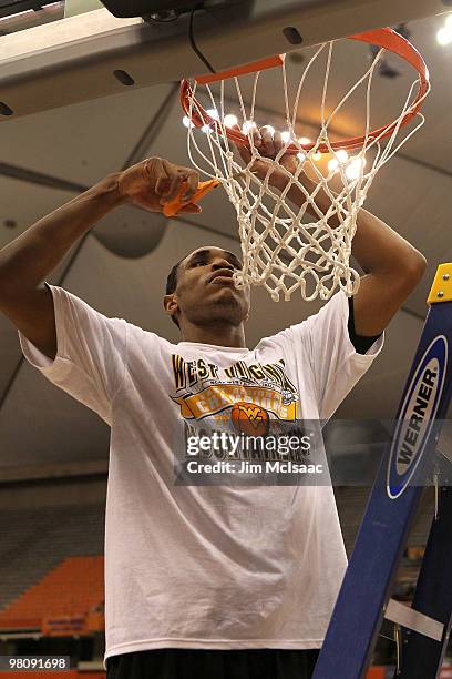 Kevin Jones of the West Virginia Mountaineers cuts down a piece of the net following West Virginia's 73-66 win against the Kentucky Wildcats during...