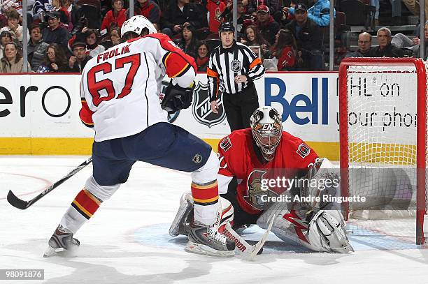 Brian Elliott of the Ottawa Senators makes a save as Michael Frolik of the Florida Panthers looks for a rebound at Scotiabank Place on March 27, 2010...