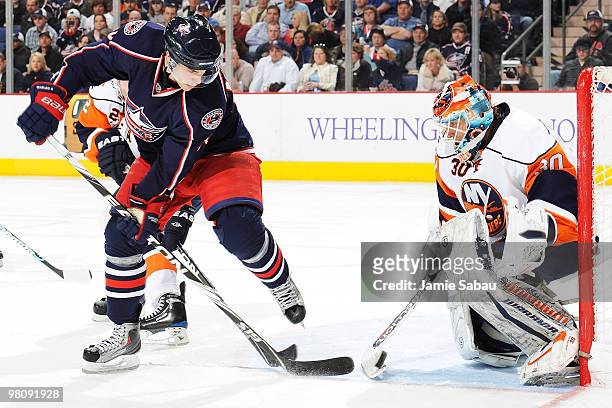 Goaltender Dwayne Roloson of the New York Islanders gets his stick on the puck after it was redirected by Derick Brassard of the Columbus Blue...