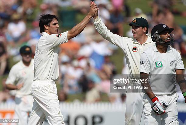 Mitchell Johnson high fives with Marcus North after taking the wicket of Jeetan Patel of New Zealand during day two of the Second Test Match between...