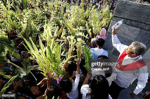 Sea of Filipino Roman Catholics wave palm leaves at a church in Bulacan, north of Manila on March 28, 2010. The Palm Sunday marks the start of the...