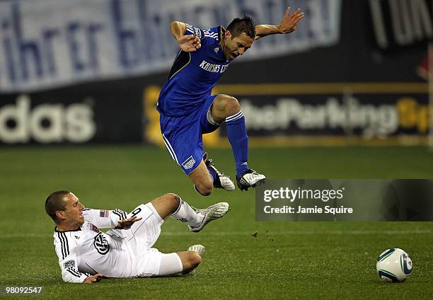 Davy Arnaud of the Kansas City Wizards leaps over a sliding Kurt Morsink of D.C United during the game on March 27, 2010 at Community America Park in...