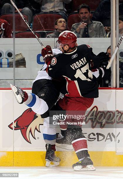 Radim Vrbata of the Phoenix Coyotes checks Kyle Quincey of the Colorado Avalanche into the boards on March 27, 2010 at Jobing.com Arena in Glendale,...