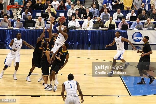 John Wall of the Kentucky Wildcats drives for a shot attempt against the West Virginia Mountaineers during the east regional final of the 2010 NCAA...