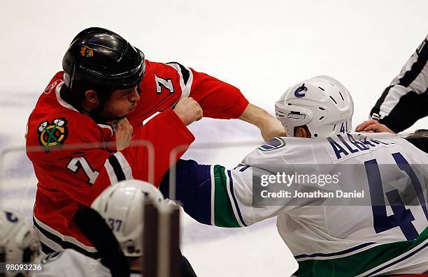 Brent Seabrook of the Chicago Blackhawks fights with Andrew Alberts of the Vancouver Canucks in the first period in front of the Canuck bench at the...