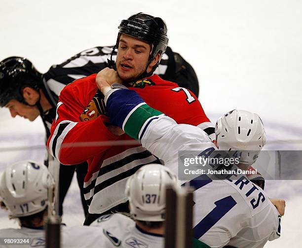 Brent Seabrook of the Chicago Blackhawks fights with Andrew Alberts of the Vancouver Canucks in the first period in front of the Canuck bench at the...