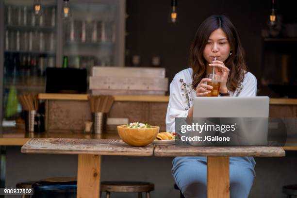 jeune femme travaillant sur son ordinateur portable dans un café - jgalione photos et images de collection