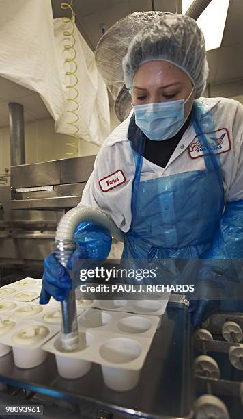 Worker in the production line at Cuisine Solutions pumps in souffle preparation during the food manufacturing process on March 23, 2010 in...