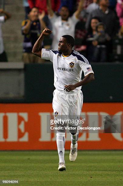 Edson Buddle of the Los Angeles Galaxy gestures to the stands after scoring in the first half during their MLS match against the New England...