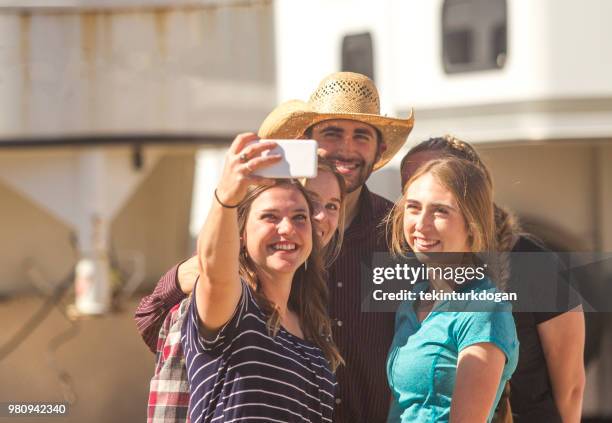 selfie prise de cow-boy avec des amis fille jeune agriculteur au ranch paddock à salt lake city slc nous - agriculteur selfie photos et images de collection