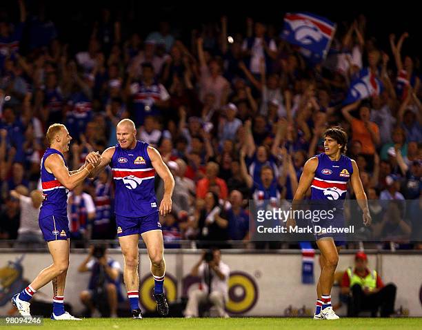 Adam Cooney congratulates Barry Hall of the Bulldogs on kicking a goal during the round one AFL match between the Western Bulldogs and the...