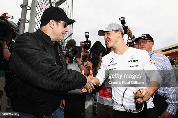 Actor John Travolta meets Michael Schumacher of Germany and Mercedes GP on the grid before the Australian Formula One Grand Prix at the Albert Park...