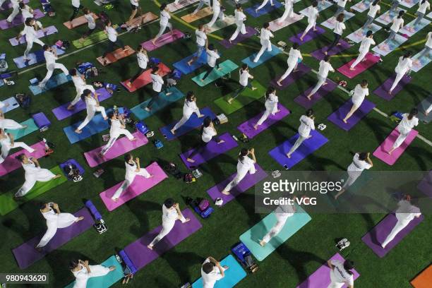Yoga enthusiasts practice Yoga at a stadium during the celebration of International Day of Yoga on June 21, 2018 in Binzhou, China.