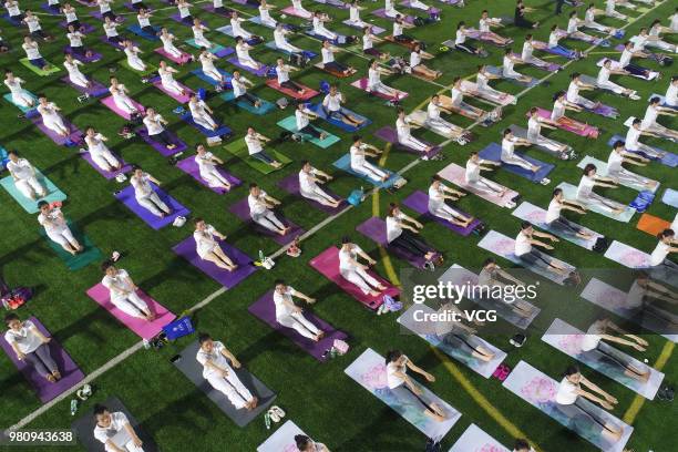 Yoga enthusiasts practice Yoga at a stadium during the celebration of International Day of Yoga on June 21, 2018 in Binzhou, China.