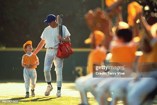 young baseball player (6-8) walking with coach, usa - winning baseball team stock pictures, royalty-free photos & images