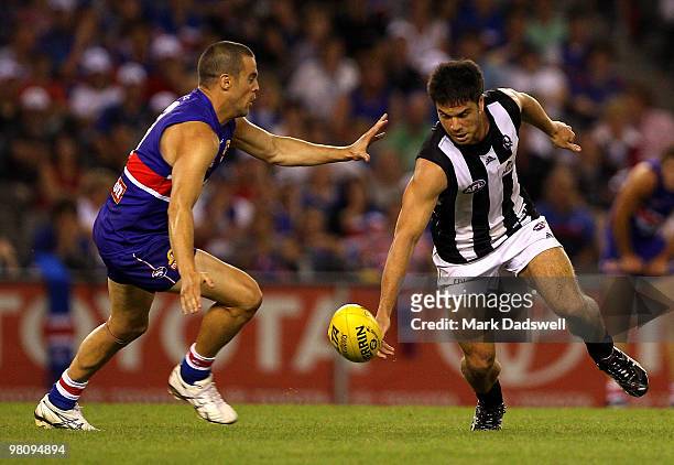 Lindsay Gilbee of the Bulldogs looks to tackle Paul Medhurst of the Magpies during the round one AFL match between the Western Bulldogs and the...