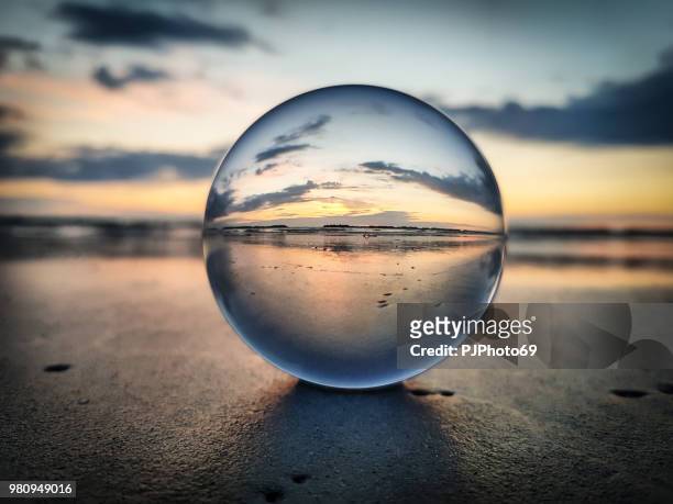 watching sunrise throught a lens ball - riviera romagnola - ball stock pictures, royalty-free photos & images
