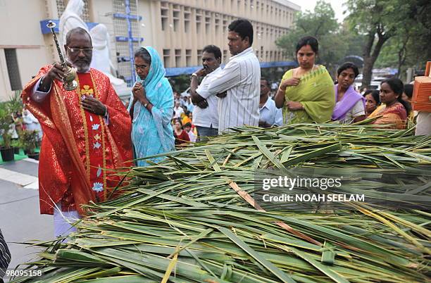 Indian Catholic Priest Reverend Father Thumma Solomonn blesses palm leaves by sprinkling holy water at the Saint Mary's Church in Secunderabad, the...