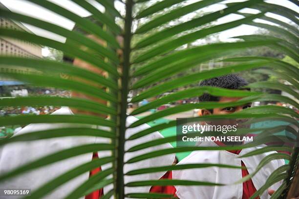 Altar boys hold palm leaves as they participate in Holy Mass at the Saint Mary's Church in Secunderabad, the twin city of Hyderabad, on March 28 on...