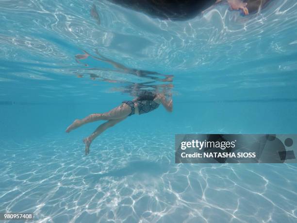 underwater photo of young girl in a swimsuit in a private pool - holding nose stock pictures, royalty-free photos & images