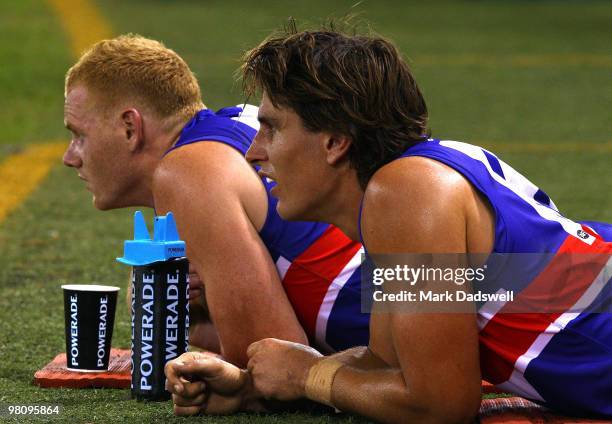 Adam Cooney and Ryan Griffin of the Bulldogs take a rest on the mat during the round one AFL match between the Western Bulldogs and the Collingwood...