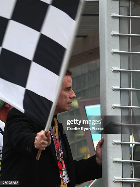 Actor John Travolta waves the chequered flag at the end of the Australian Formula One Grand Prix at the Albert Park Circuit on March 28, 2010 in...