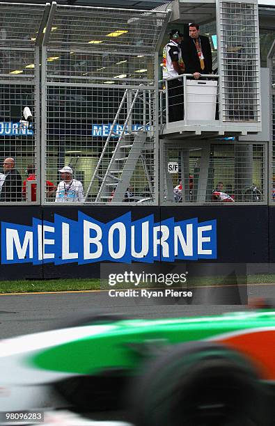 Actor John Travolta looks on as he prepares to wave the chequered flag at the end of the Australian Formula One Grand Prix at the Albert Park Circuit...