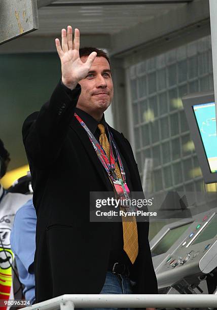 Actor John Travolta waves to fans as he prepares to wave the chequered flag at the end of the Australian Formula One Grand Prix at the Albert Park...