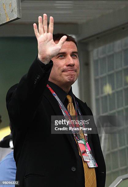 Actor John Travolta waves to fans as he prepares to wave the chequered flag at the end of the Australian Formula One Grand Prix at the Albert Park...