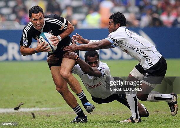 Zar Lawrence of New Zealand attempts to run through a tackle by Jiuta Lutumailagi and Watisoni Votu of Fiji during their Cup semi-final match on the...
